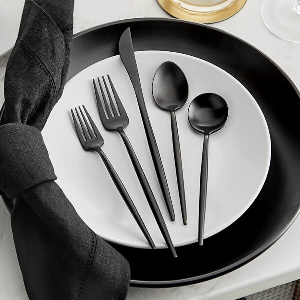 Acopa Odin black stainless steel fork and knife on a white plate.