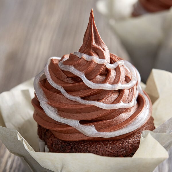 A chocolate cupcake with Satin Ice Silver Vanilla Glitter Glaze frosting on top.