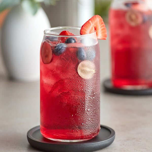 A glass of Tractor Beverage Co. Farmer's Punch with fruit on top.