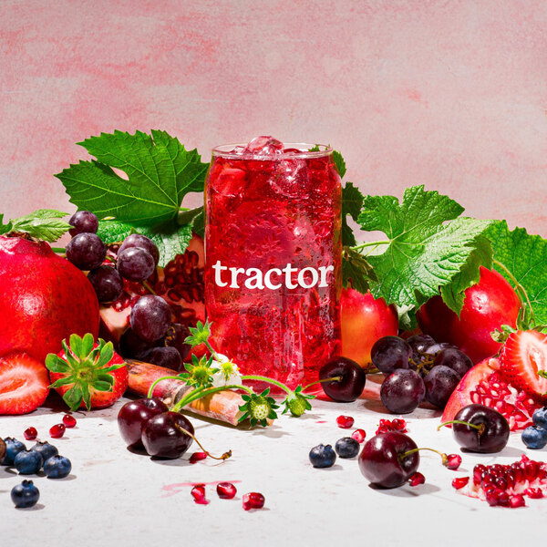 A glass of Tractor Beverage Co. Farmer's Punch with ice and fruit.