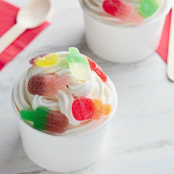 Two cups of ice cream with Vidal gummy candy on top.