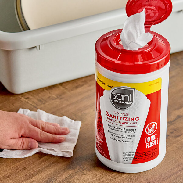 A hand using a Sani Professional sanitizing wipe to clean a surface.