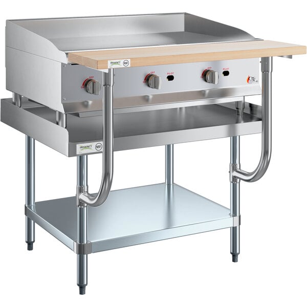 A stainless steel Cooking Performance Group gas griddle on a wooden top chef station.
