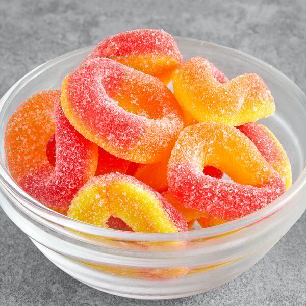 A bowl of Kervan Gummy Peach Rings on a gray surface.