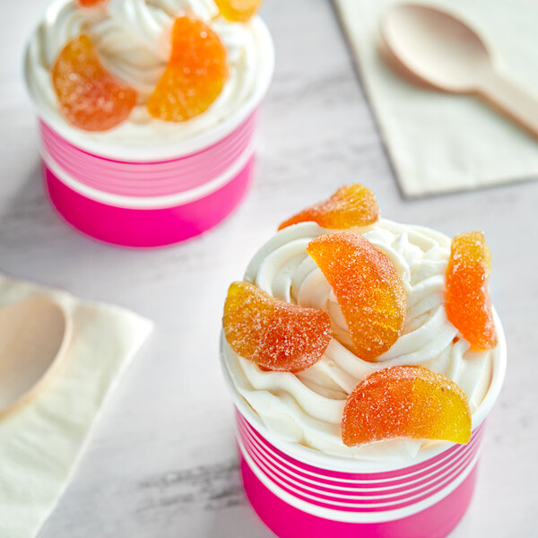 Two cups of ice cream with Kervan Sugared Gummy Orange Slices on top.