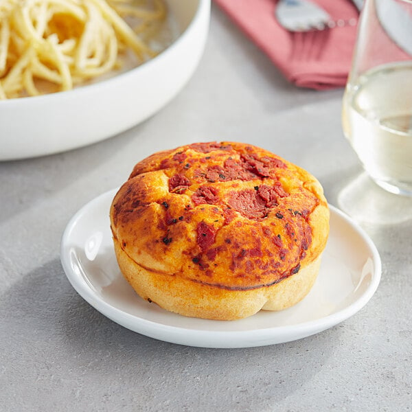 A plate with a Turano Tomato and Basil Focaccina Roll with a pizza on it.