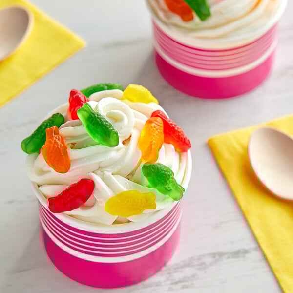 A cup of ice cream with Kervan assorted colored gummy fish on top.