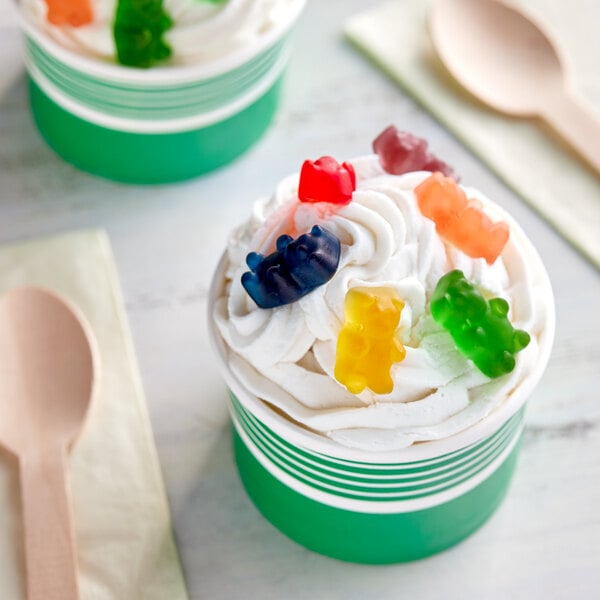 A green gummy bear on a white surface.