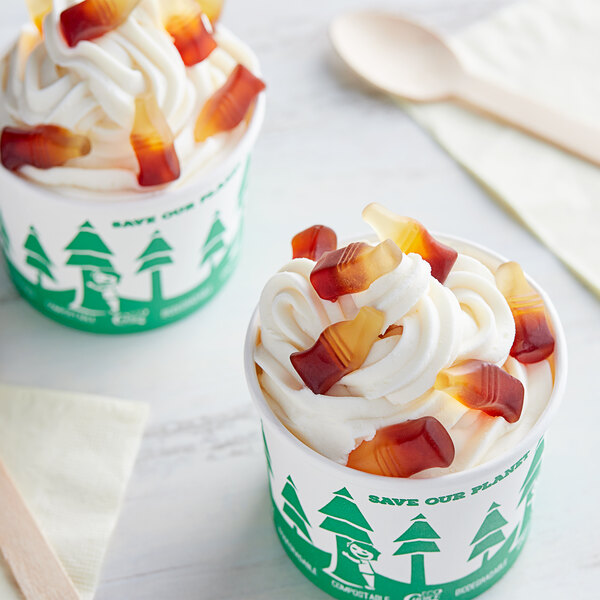 Two cups of ice cream with Kervan Gummy Cola Bottles on top.