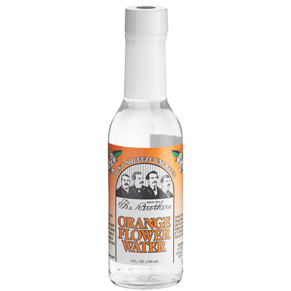 A close up of a clear Fee Brothers Orange Flower Water bottle with an orange label.