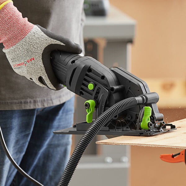 A person using a Genesis compact circular saw to cut wood.