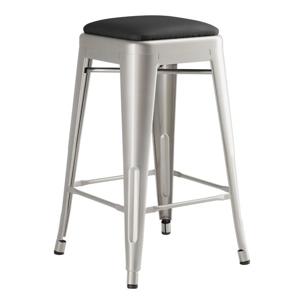 A Lancaster Table & Seating metal backless counter height stool with black vinyl cushion.