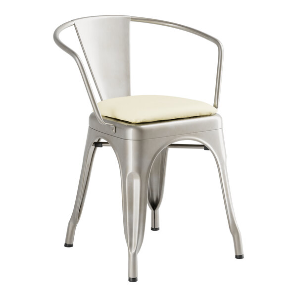 A Lancaster Table & Seating silver metal arm chair with a white cushion.