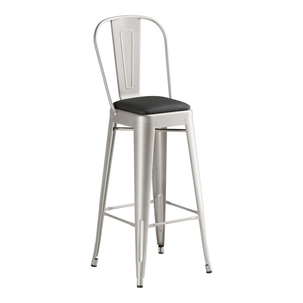 A Lancaster Table & Seating metal barstool with black cushion.