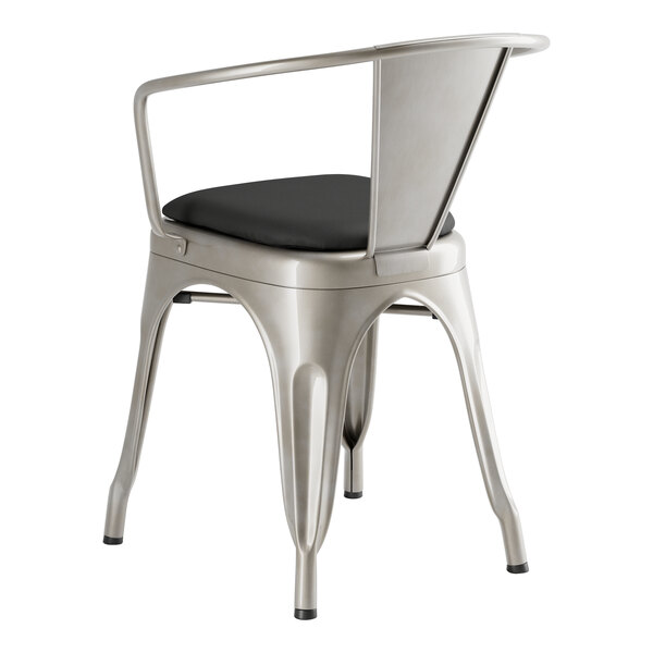 A Lancaster Table & Seating metal arm chair with a black cushion.