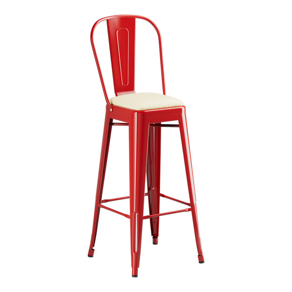 A Lancaster Table & Seating red metal barstool with a white cushion.