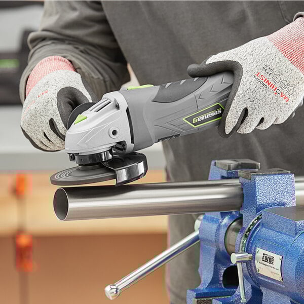 A person using a blue and silver Genesis angle grinder with a circular handle to grind a metal pipe.