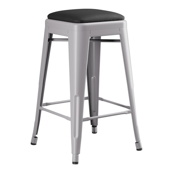 A Lancaster Table & Seating gray metal backless counter height stool with a black seat.