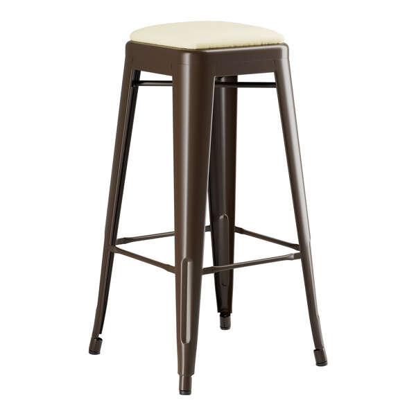 A brown metal Lancaster Table & Seating backless barstool with a white cushion seat.