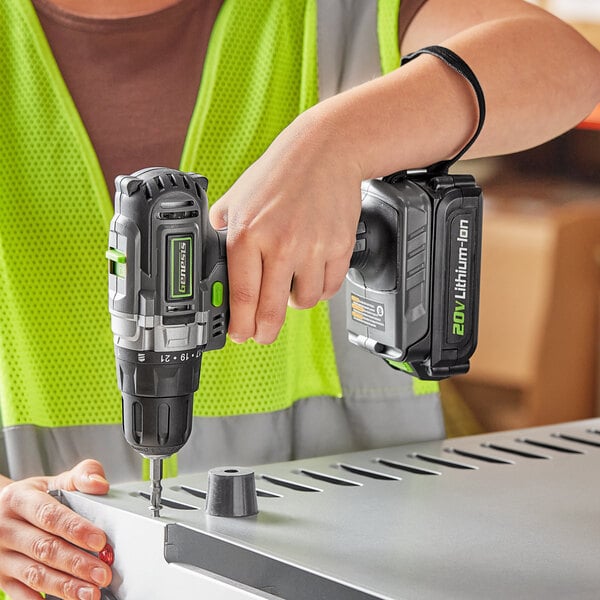 A person using a Genesis cordless drill to make a hole in metal.
