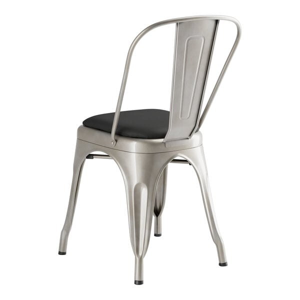 A Lancaster Table & Seating metal chair with black cushion.