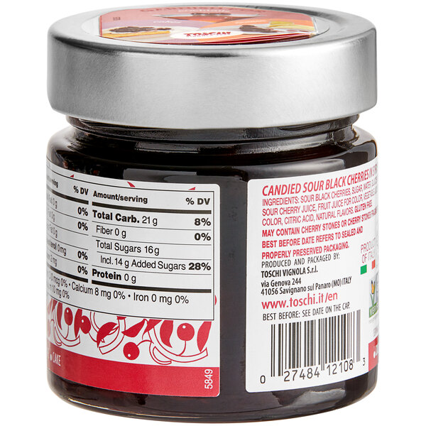 A close up of a jar of Toschi Amarena Cherries in Syrup on a table with a label.