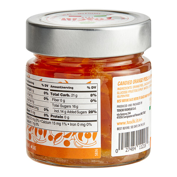 A jar of Toschi Orange Peels in Syrup on a table with a label.
