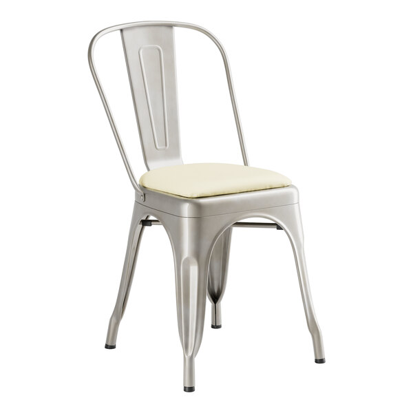 A Lancaster Table & Seating metal indoor cafe chair with a white cushion.