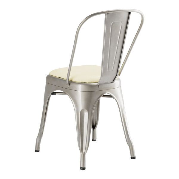 A Lancaster Table & Seating metal cafe chair with white cushion.