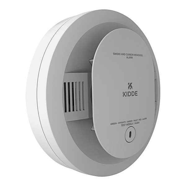 A close-up of a white Kidde smoke and carbon monoxide alarm with a small button.