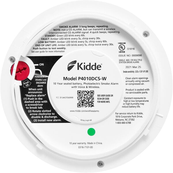 A Kidde white circular smoke alarm with black and red text.