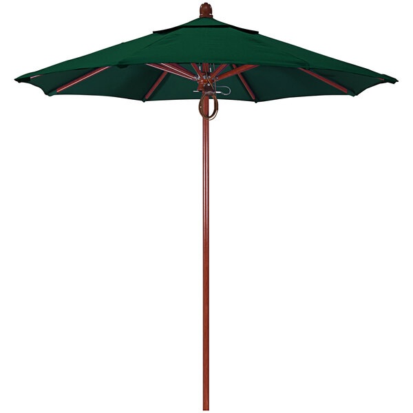 A green California Umbrella on a wooden pole.