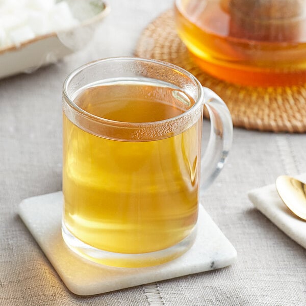 A glass mug of Davidson's Organic Detox Herbal tea on a coaster.