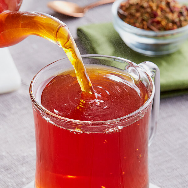 A glass mug of Davidson's Organic Christmas Herbal tea with a tea bag in it.