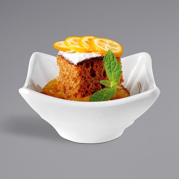 A white APS Minis melamine bowl with a piece of cake and fruit.