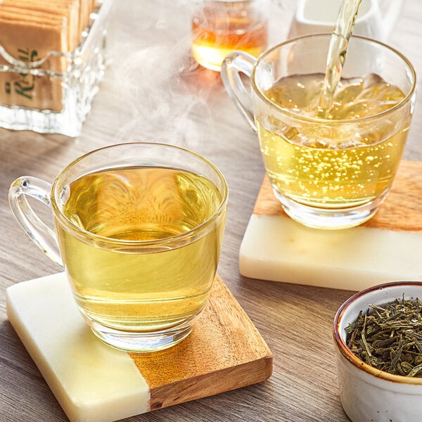 Davidson's Organic Sencha Loose Leaf Tea being poured into a glass cup of tea.