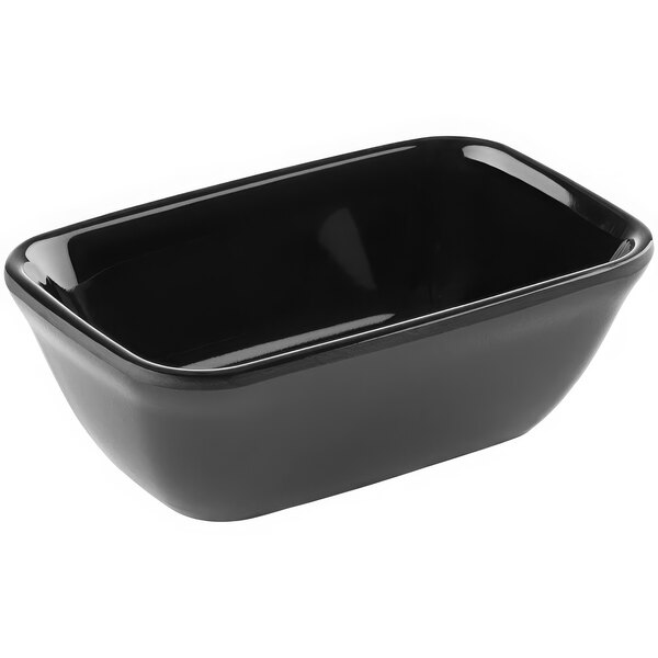 An APS 3.3 oz. black rectangular melamine bowl on a counter.