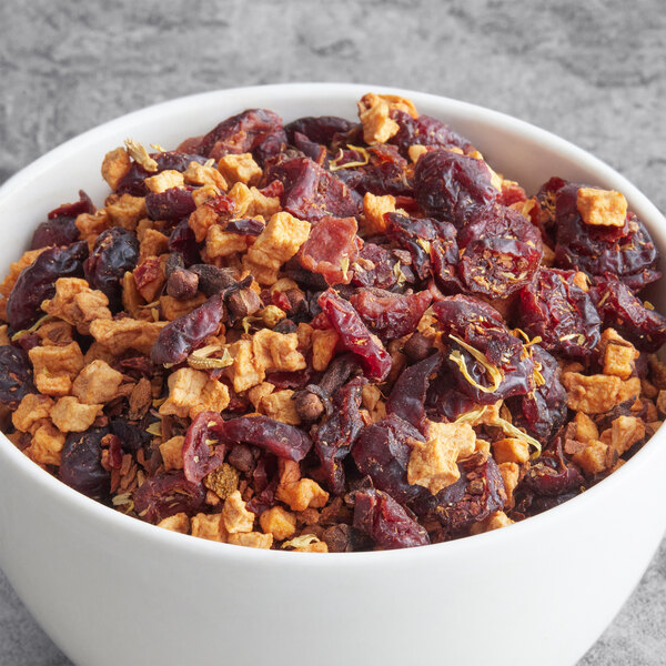 A bowl of Davidson's Organic Autumn Fruit and Flowers Herbal Loose Leaf Tea with dried cranberries and oranges.