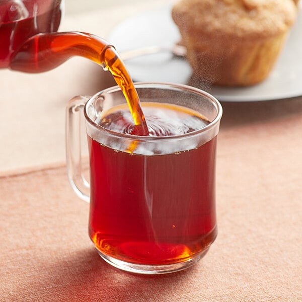 Davidson's Organic Red Passion Herbal tea being poured into a glass cup.