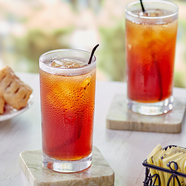 A glass of Davidson's Organic Vanilla Iced Tea on a table with a plate of cookies.