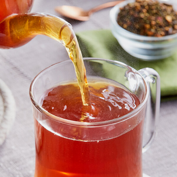 Davidson's Organic Christmas Loose Leaf Tea being poured into a glass cup.