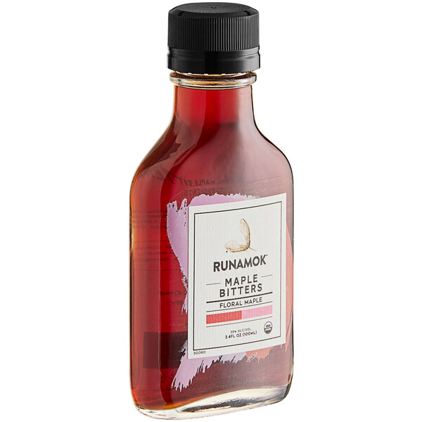 A close up of a bottle of Runamok Floral Maple Bitters with a black cap and a red label.