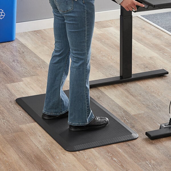 A person standing on a black 360 Office Furniture anti-fatigue mat.