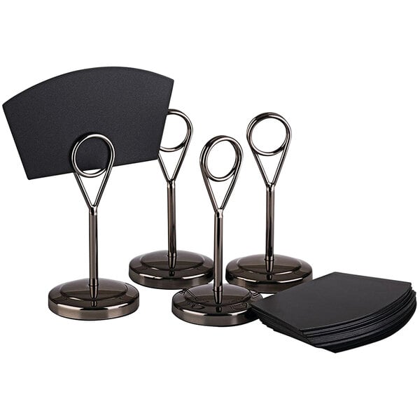 A set of 24 black stainless steel APS menu/card holders on a counter with black cards.