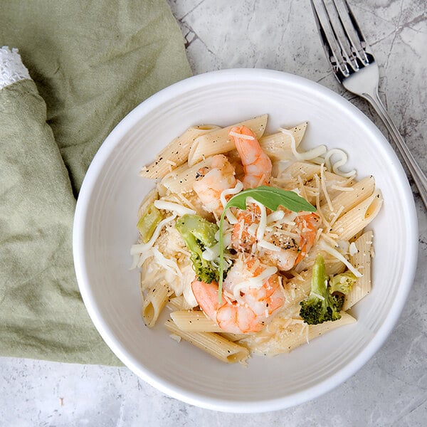 A plate of penne pasta with shrimp and broccoli.