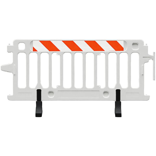 A close-up of a white Plasticade barricade with orange and white striped sheeting on it.