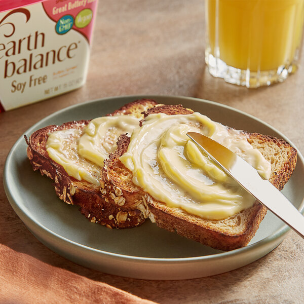A plate of toast with Earth Balance Vegan Soy Free Buttery Spread on it next to a glass of orange juice.