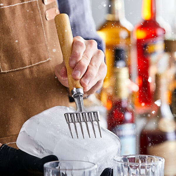 A person using an Acopa steel ice chipper to make ice.