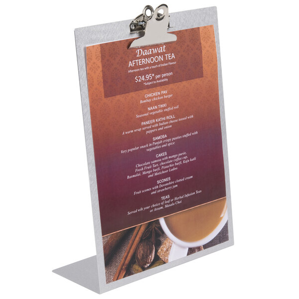 An aluminum Menu Solutions Alumitique menu tent with a clip holding a menu.
