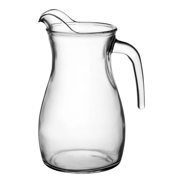 A clear glass pitcher with a handle.